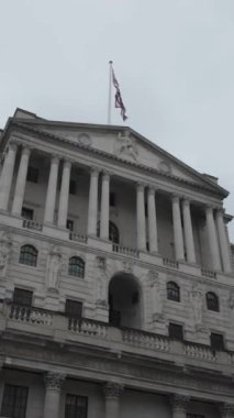 İngiltere 'nin görkemli bankası bulutlu bir gökyüzü altında neoklasik mimarisini sergiliyor. Dikey Video