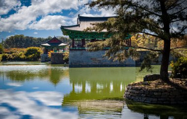 Traditional korean architecture reflecting on the lake at the gyeongbokgung palace in seoul, south korea, on a sunny day with clouds and blue sky clipart