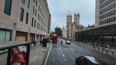 Londra, İngiltere. 20 Ekim 2024: Londra sokaklarında dolaşan kırmızı çift katlı otobüs ikonik simgelerden ve kalabalık kalabalıklardan geçiyor.