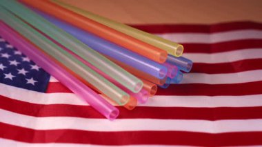 Amerikan bayrağında plastik pipetler ve idari emir notu. ABD hükümetlerinin plastik saman yasağını geri çevirme kavramı