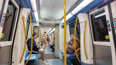 Madrid, İspanya. Aralık 2023: Yolcular Madrid metrosunda akıllı telefon kullanıyorlar