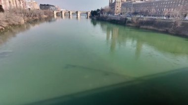 Ebro nehrinin yeşil suları Zaragoza 'da akıyor bazilika del pilar görkemli bir şekilde nehir kıyısında duruyor.