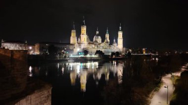 Zaragozas Bazilika del Pilar 'ı aydınlattı ve gece Ebro Nehri' ni yansıttı.