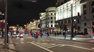 Madrid, İspanya. 15 Mart 2025: Metropolis binası ve Madrid 'deki Circulo de Bellas Sanat binası yakınlarındaki Alcala caddesinde gece araba ve otobüsler sürüyor.