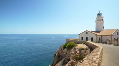 Beyaz capdepera deniz feneri, Mallorca 'daki mavi Akdeniz manzaralı bir uçurumun kenarında duruyor. Balkulak adaları, İspanya.