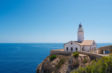 Beyaz capdepera deniz feneri, Mallorca 'daki mavi Akdeniz manzaralı bir uçurumun kenarında duruyor. Balkulak adaları, İspanya.