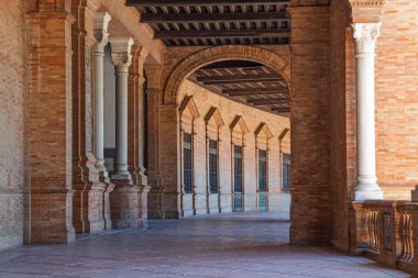 Seville 'deki Plaza de Espana koridorunu aydınlatan güneş ışığı tuğla, kemer ve sütunların eşsiz karışımını sergiliyor.