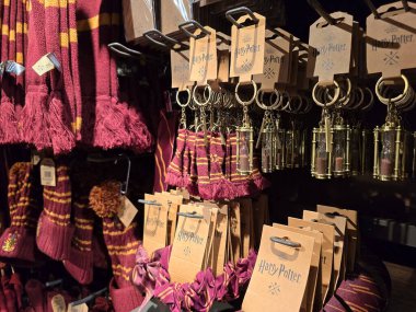 Londra, İngiltere. Nisan 17, 2025: Bir mağazada eşarplar, saat gözlüklü anahtarlıklar ve saç aksesuarları sergilenen resmi Harry Potter ürünleri