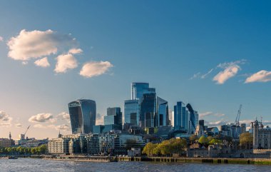 Londra 'nın sembolik simgelerini barındıran şehir manzarası. Telsiz sesli bina ve bulutlarla benekli mavi gökyüzünün altındaki Londra kulesi gibi.