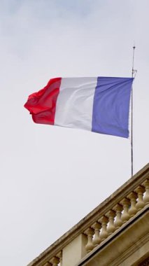 Bir binada ağır çekimde dalgalanan Fransız bayrağı