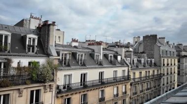 Paris 'in zarif mimarisi bulutlu bir gökyüzünün altında yatakhane pencerelerini ve balkonlarını sergiliyor.