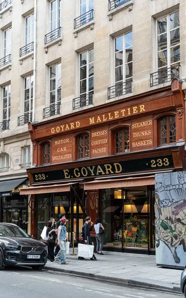 Paris, Fransa. 14 Mayıs 2025 'te Paris' teki Goyard Malletier mağazasının önünden geçen müşteriler, el yapımı bavulları ve deri eşyalarıyla tanınan lüks bir marka.