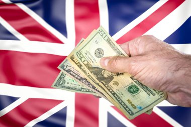 İngiltere ve ABD arasındaki serbest ticaret anlaşmasını temsil eden, geçmişinde İngiliz bayrağı olan bir grup Amerikan banknotuyla el ele tutuşmak..