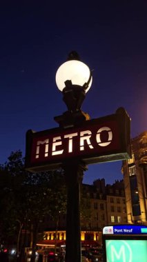 Paris, Fransa. 15 Mayıs 2025, Parlayan metro tabelası Pont Neuf yakınlarında Paris alacakaranlığını aydınlatıyor.