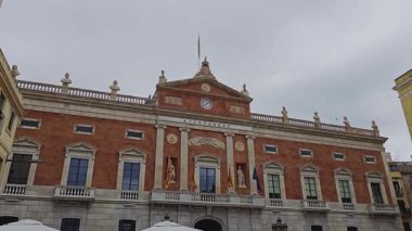 Tarragona, İspanya. 24 Temmuz 2025 'te insanlar Placa de la Font' taki açık hava restoranında yemek yerken arka planda Tarragona Belediye Binası vardı.