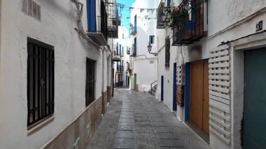 Beyaz duvarlar ve mavi pencereler Peniscola, İspanya 'da dar bir sokak.
