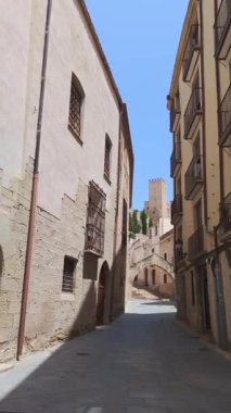 İspanya 'nın Tortosa şehrinde balkonları ve Suda kalesi olan dar bir sokak.