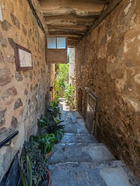 Tarihi Valldemossa, Mallorca, İspanya 'da UNESCO Dünya Mirası sahasında dar bir sokağa çıkan taş basamaklar dizili saksı bitkileri.