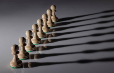 Beyaz tahta piyonların çapraz çizgisi seçici odaklı ve yerde gölge oyunu