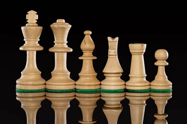Line of wooden white chess pieces isolated at background with transparent reflection on the floor