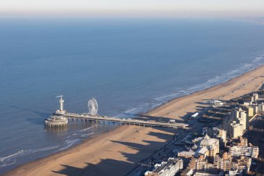 Hollanda kıyılarında dönme dolabı olan Hollanda Scheveningen İskelesi sahilde uzun gölgeli Kurhaus