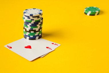 Poker çipleri ve renkli arkaplanda oyun kartları.