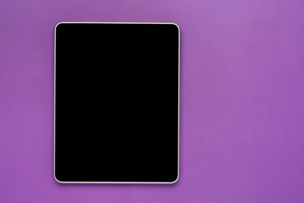 紫のパステルカラーの背景にタブレットのトップビュー — ストック写真