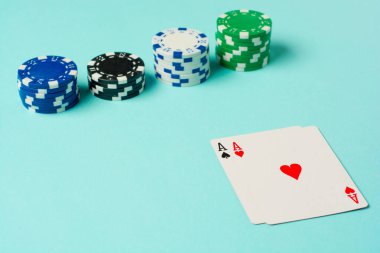 Poker çipleri ve renkli arkaplanda oyun kartları.