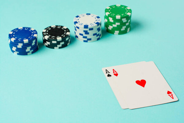 Poker chips and playing cards on colorful background.
