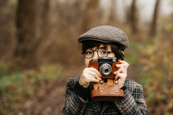 公園でぼやけた背景にレトロカメラを持つ男の子 — ストック写真
