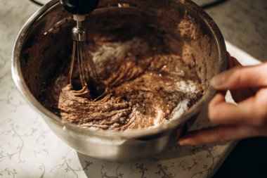 Adım adım çikolatalı kek yapma süreci, çörekler. Hamuru karıştırıcı kasede kakaoyla döv. Pişirme kavramı.