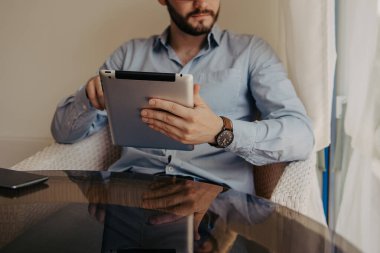 Close. İş yemeğinde tablette çalışan ve kahve içen işadamı.