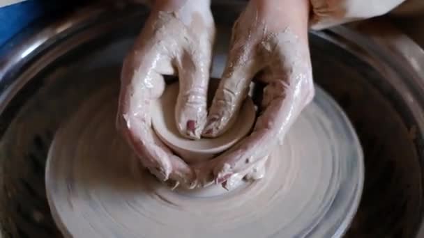 陶工の手のクローズアップは ポッターホイール上の粘土のポットピッチャーを彫刻します — ストック動画