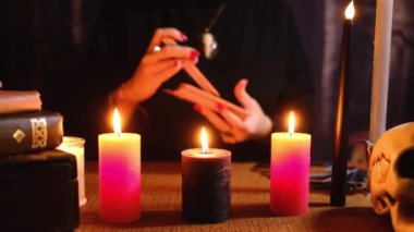 Bir kadın Tarot güvertesini karıştırıyor, gelecekteki kaderi tahmin etmek için istişareye hazırlanıyor. Falcı, medyum, falcı..