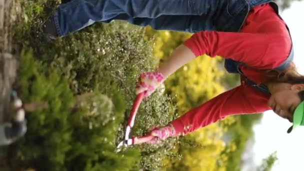 Female Gardener Wearing Gloves Performs Repair Work Trims Bushes Garden — Stock Video
