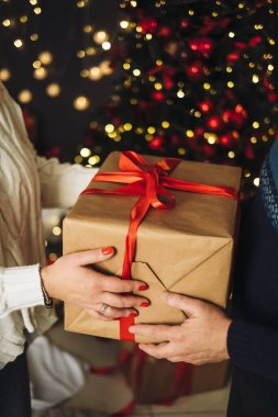 Erkek, sevgilisine mücevher hediye kutusunu sunar. Yakın plan, yeni yıl kutlaması.