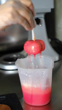 Bir tatlı yaratma süreci. Atölyedeki bir pasta şefi kalp şeklinde bir tatlıyı parlatıyor. Bir pasta şefi kalp şeklinde bir krema hazırlar..