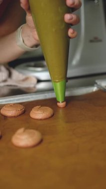 Makaronları pişirme tepsisine bastırıyorum. Pişirme konsepti. Makarna tatlısı. Fransız tatlısı yapıyorum. Yakın plan.