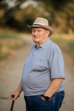 Şapkalı büyükbaba. Çok yaşlı bir beyaz adamın portresi. Portre: yaşlı, yalnız, yaşlı, yüzünde kırışıklıklar var. Dışarıda tek başına duran düşünceli yaşlı bir adamın yakın çekimi..