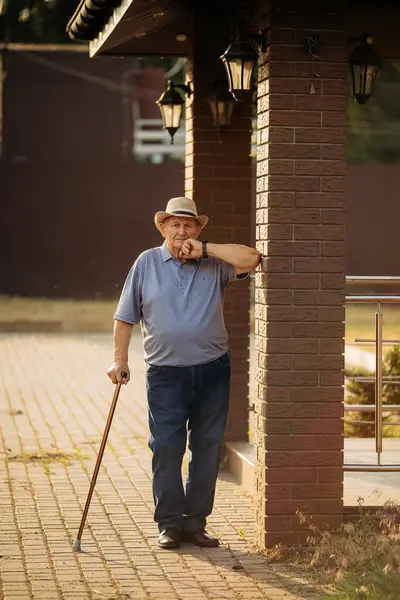 Şapkalı büyükbaba. Çok yaşlı bir beyaz adamın portresi. Portre: yaşlı, yalnız, yaşlı, yüzünde kırışıklıklar var. Dışarıda tek başına duran düşünceli yaşlı bir adamın yakın çekimi..