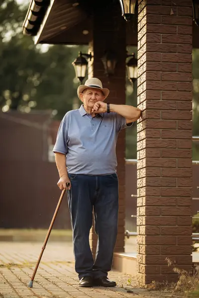 Şapkalı büyükbaba. Çok yaşlı bir beyaz adamın portresi. Portre: yaşlı, yalnız, yaşlı, yüzünde kırışıklıklar var. Dışarıda tek başına duran düşünceli yaşlı bir adamın yakın çekimi..