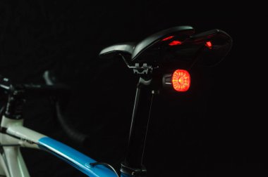 Siyah zemin üzerinde aydınlatılmış bisiklet arka lambası yakın plan