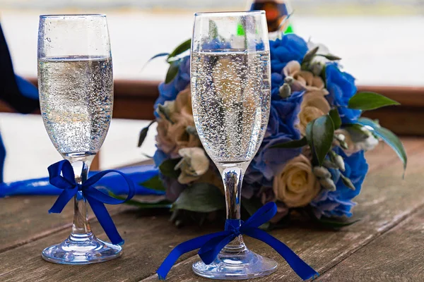 champagne in wedding glasses, standing near the bride\'s bouquet