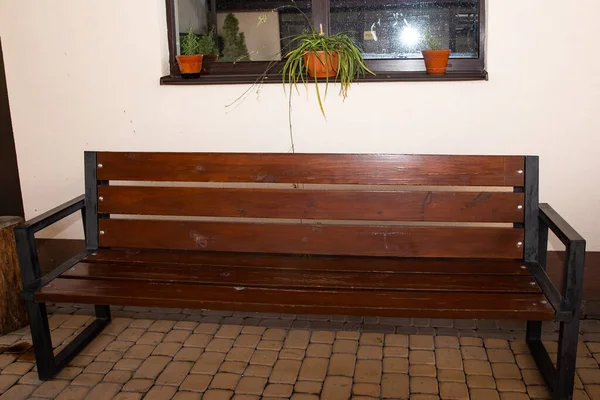 a large brown bench in the house near the window