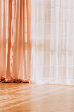 Perdeler ve tüller, güneş ışınlarının geçtiği pencereye asılır.