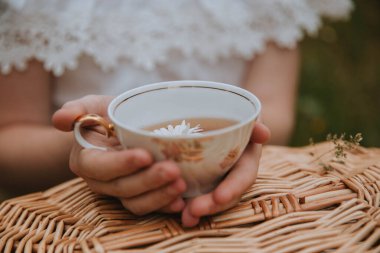 Papatya çiçekli bir fincan siyah çay.