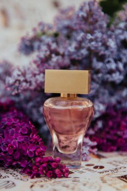 Çiçeklerin arasında bir şişe parfüm.