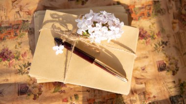 Kraft zarflarına ip ve çiçeklerle bağlanmış kalem, güzel duvar kağıtları, klasik temalı fotoğraflar, kırtasiye, ofis.