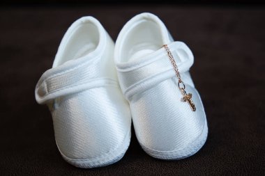 Haçı olan yeni doğmuş bir bebek için beyaz çorap ya da terlik, bebeğin vaftiz töreni için kıyafet.