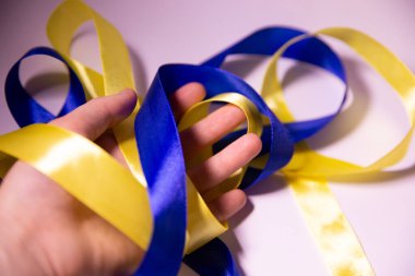 Elinde sarı-mavi kurdele, elinde saten kurdele, elinde Ukrayna bayrağı renginde kurdele.